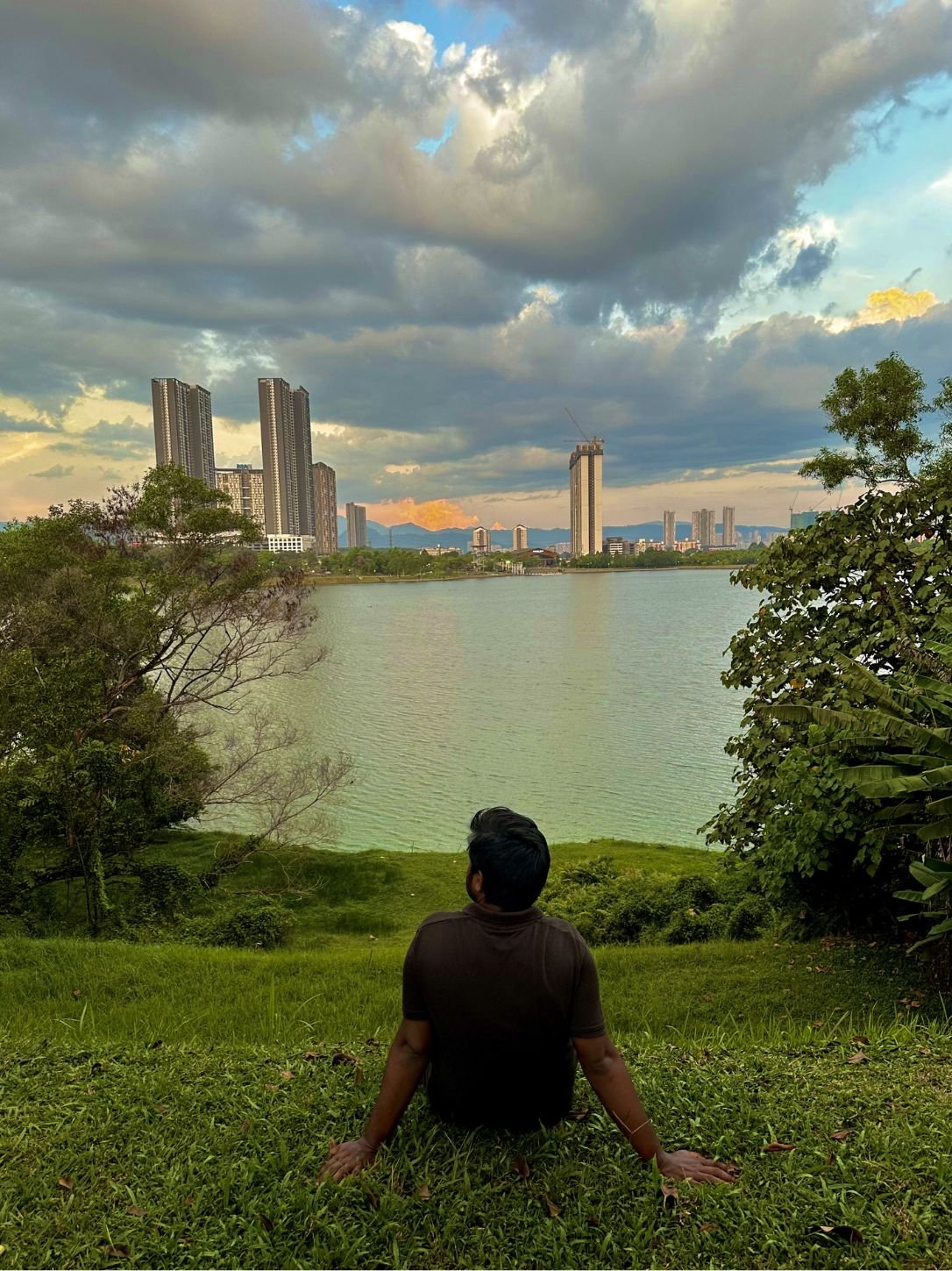 Mo sitting on the grass looking at the lake